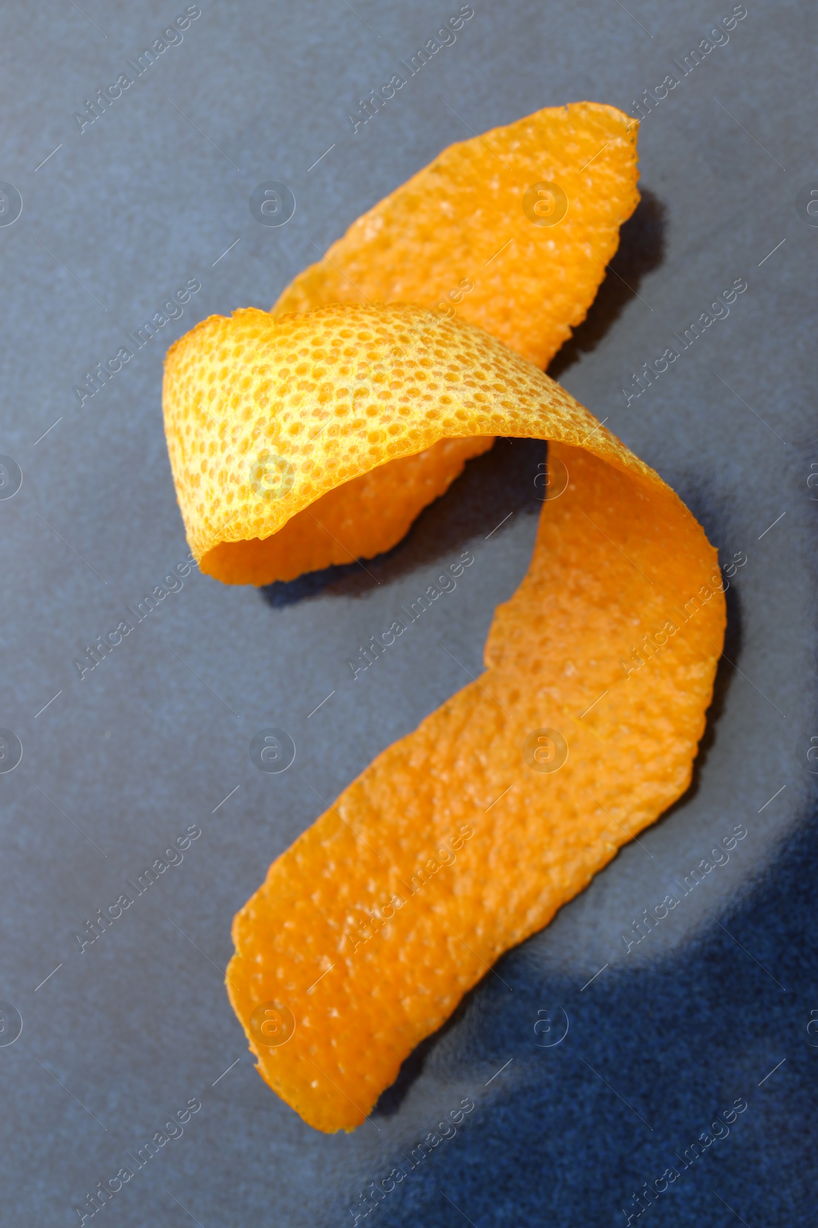 Photo of Fresh orange peel on blue table, closeup