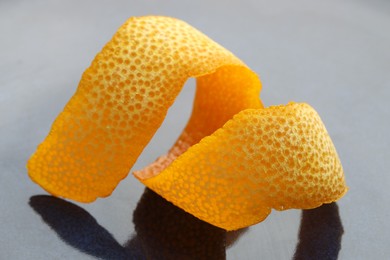 Photo of Fresh orange peel on blue table, closeup