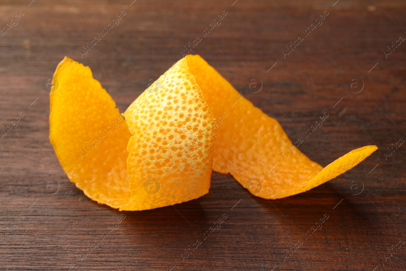 Photo of Fresh orange peel on wooden table, closeup