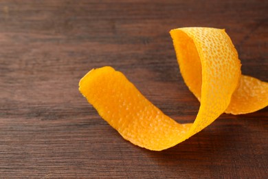 Photo of Fresh orange peel on wooden table, closeup