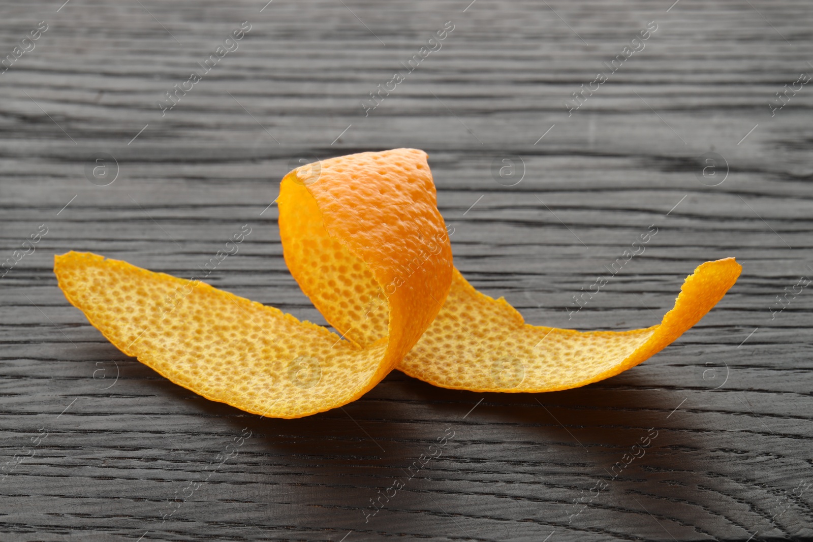 Photo of Fresh orange peel on wooden table, closeup