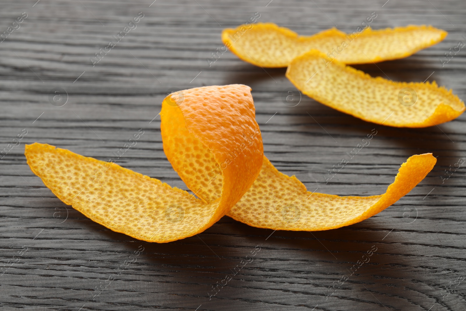 Photo of Fresh orange peels on wooden table, closeup