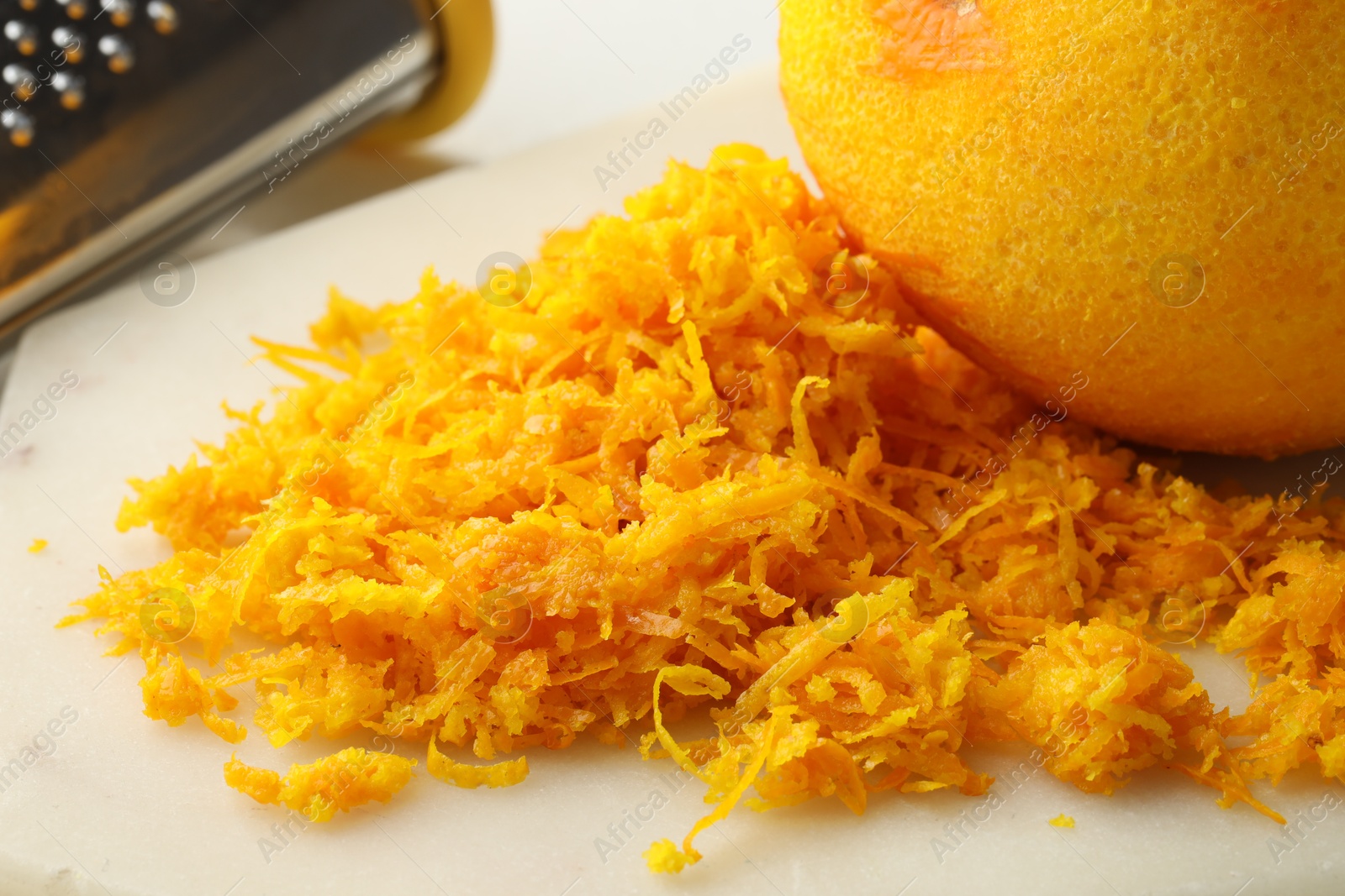 Photo of Fresh orange zest on light board, closeup