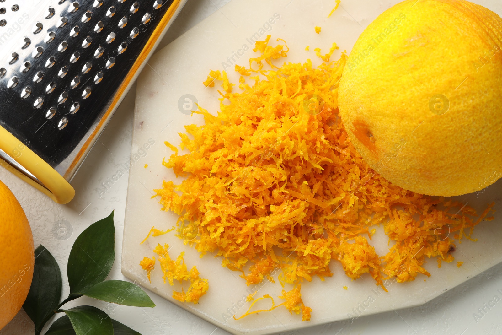 Photo of Fresh orange zest, grater and fruits on light table, flat lay