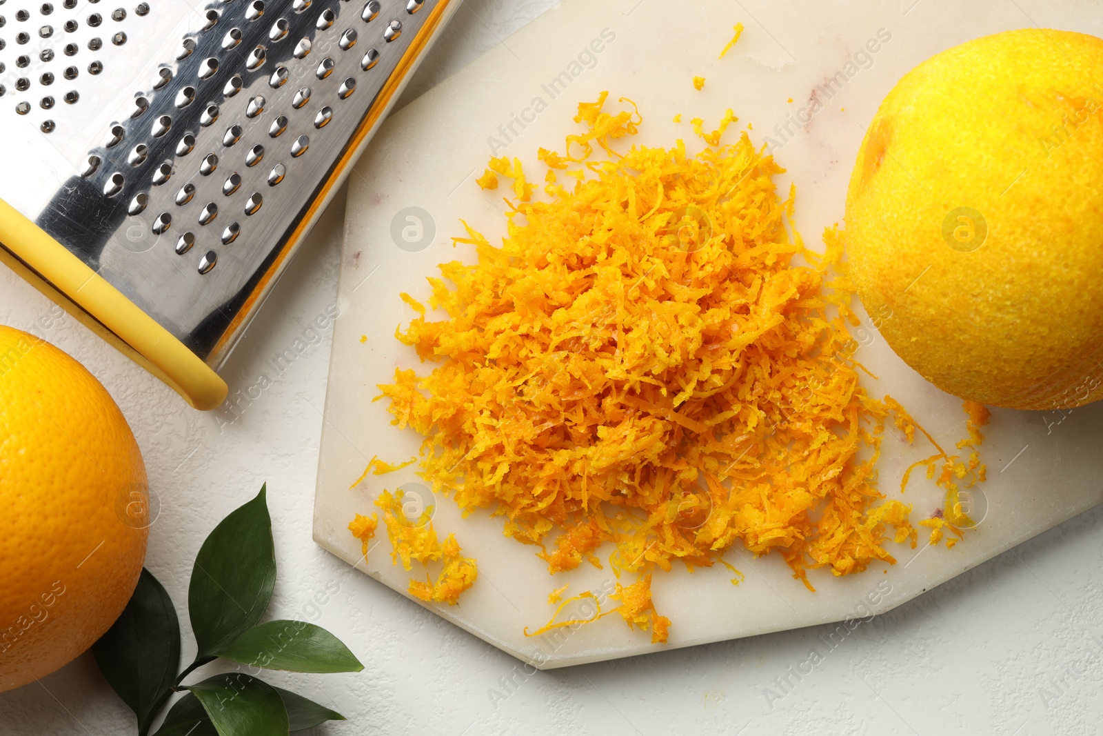 Photo of Fresh orange zest, grater and fruits on light table, flat lay