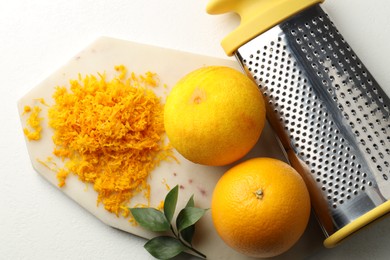 Photo of Fresh orange zest, grater and fruits on light table, flat lay