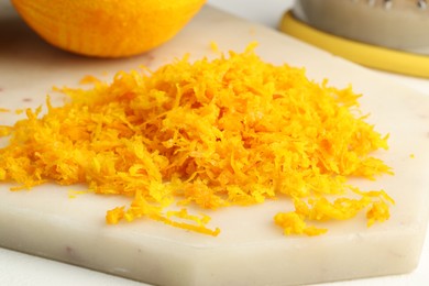 Fresh orange zest on light board, closeup