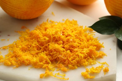 Photo of Fresh orange zest and fruits on light table, closeup