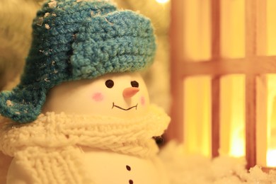 Photo of Cute decorative snowman against blurred background, closeup