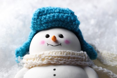 Photo of Cute decorative snowman on artificial snow, closeup