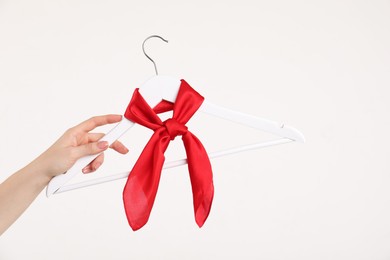 Photo of Woman holding hanger with red handkerchief on white background, closeup