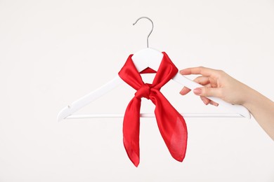 Photo of Woman holding hanger with red handkerchief on white background, closeup