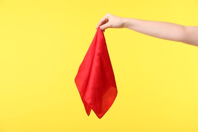 Photo of Woman holding red handkerchief on yellow background, closeup. Space for text