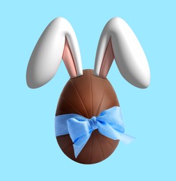 Illustration of Happy Easter. Chocolate egg with bunny ears and bow on light blue background