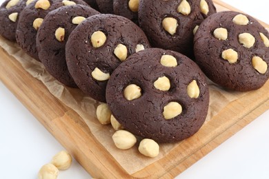 Photo of Tasty chocolate cookies with hazelnuts on white table, closeup