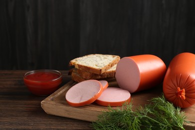 Photo of Tasty boiled sausages, ketchup, dill and bread on wooden table