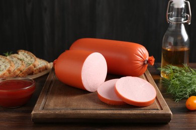 Photo of Tasty boiled sausages, ketchup, dill, oil and bread on wooden table, closeup