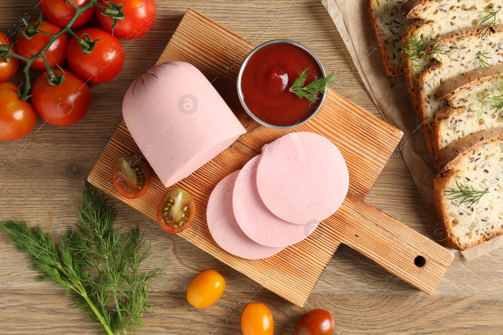 Photo of Tasty boiled sausage, ketchup, tomatoes, dill and bread on wooden table, top view