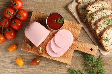 Photo of Tasty boiled sausage, ketchup, tomatoes, dill and bread on wooden table, top view