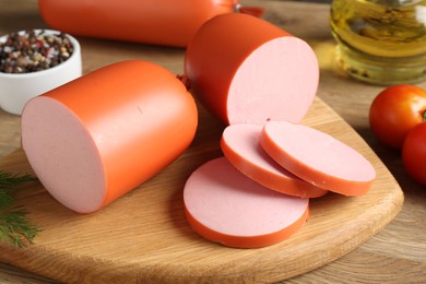 Photo of Tasty boiled sausages and spices on wooden table, closeup