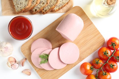 Photo of Tasty boiled sausage, spices, tomatoes, ketchup and bread on white table, top view