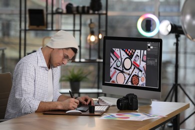 Professional retoucher working on computer in office