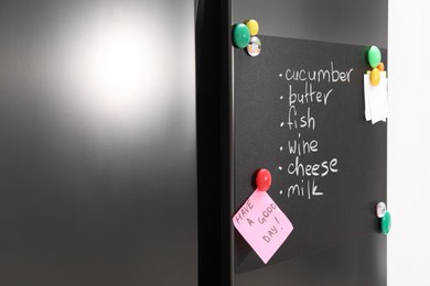 Magnetic board with shopping list and notes on refrigerator in kitchen