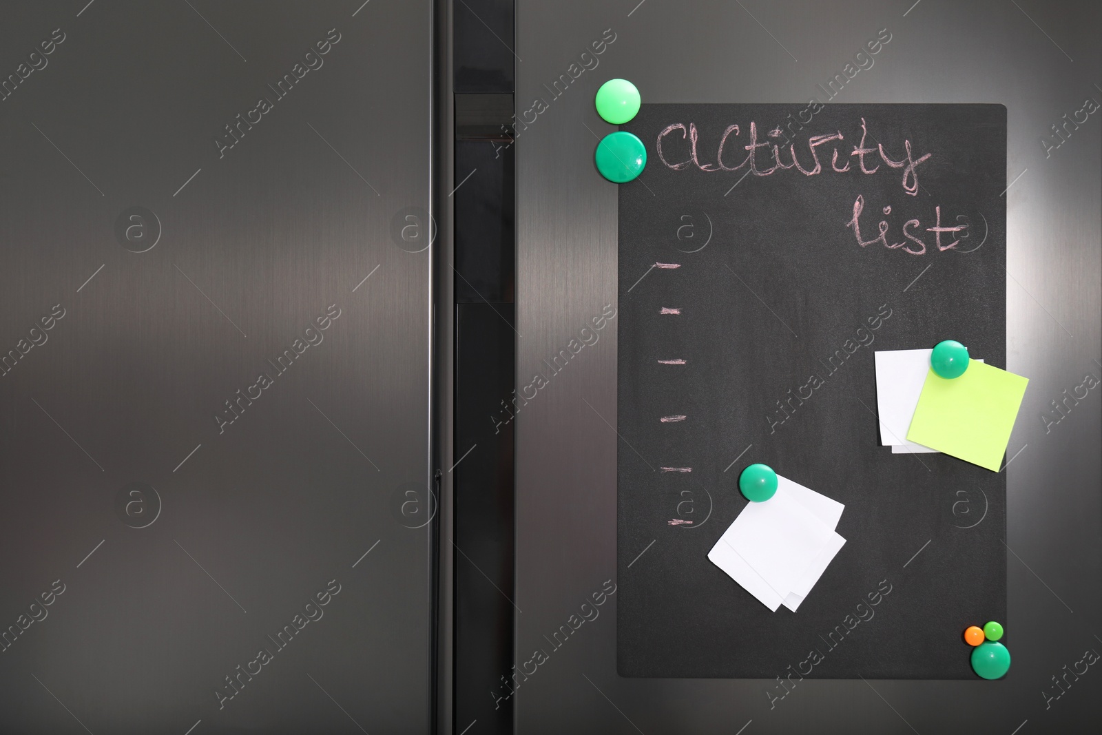 Photo of Magnetic board with activity list and notes on refrigerator in kitchen