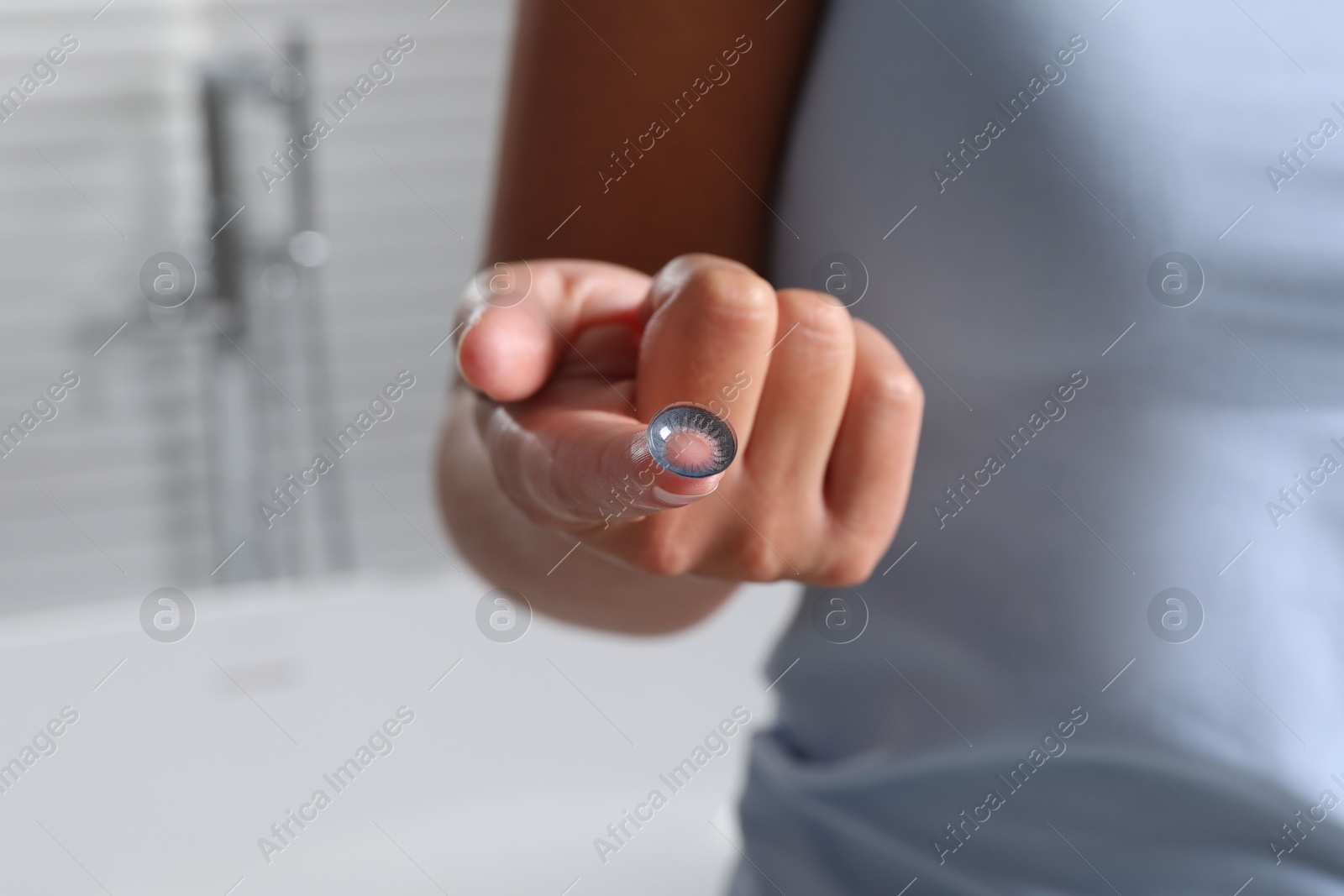 Woman holding color contact lens indoors, closeup Photo of Woman holding color contact lens indoors, closeup