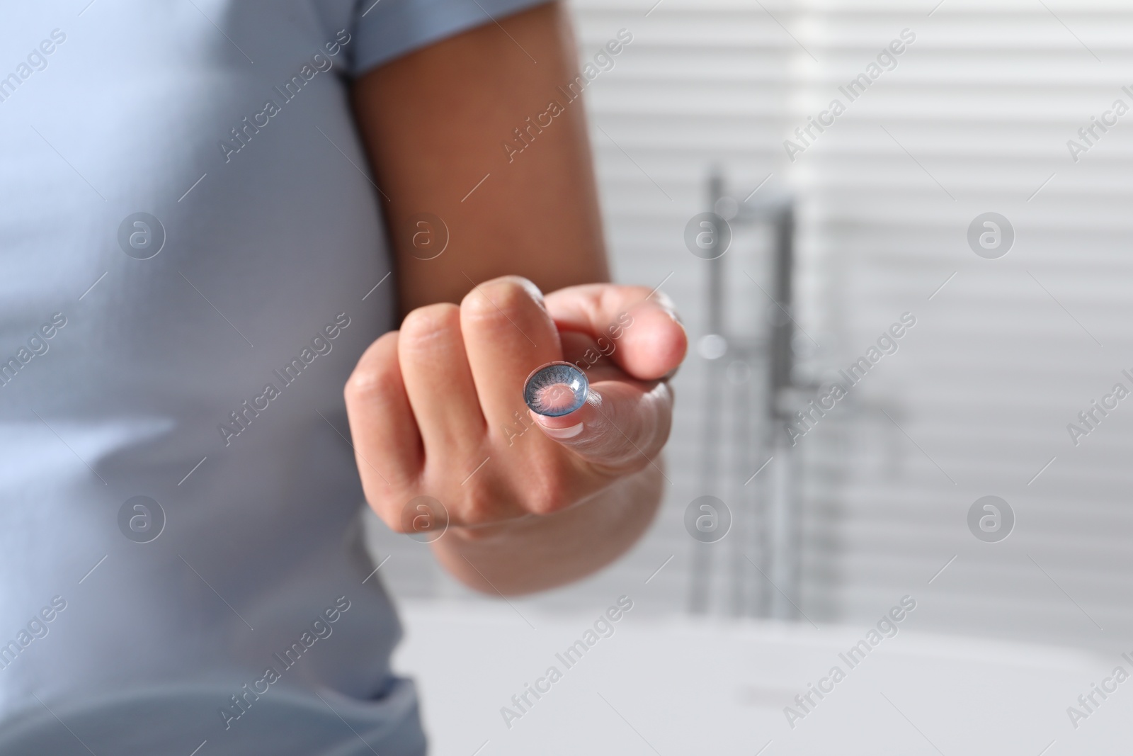 Photo of Woman holding color contact lens indoors, closeup