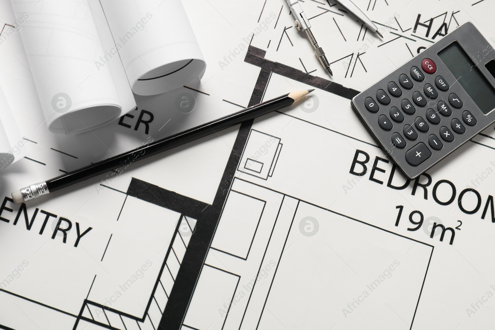 Photo of Calculator, pencil and dividers on different architectural drawings, top view