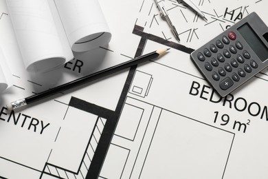 Calculator, pencil and dividers on different architectural drawings, top view