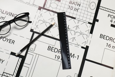 Photo of Ruler, glasses and pencil on different architectural drawings, top view