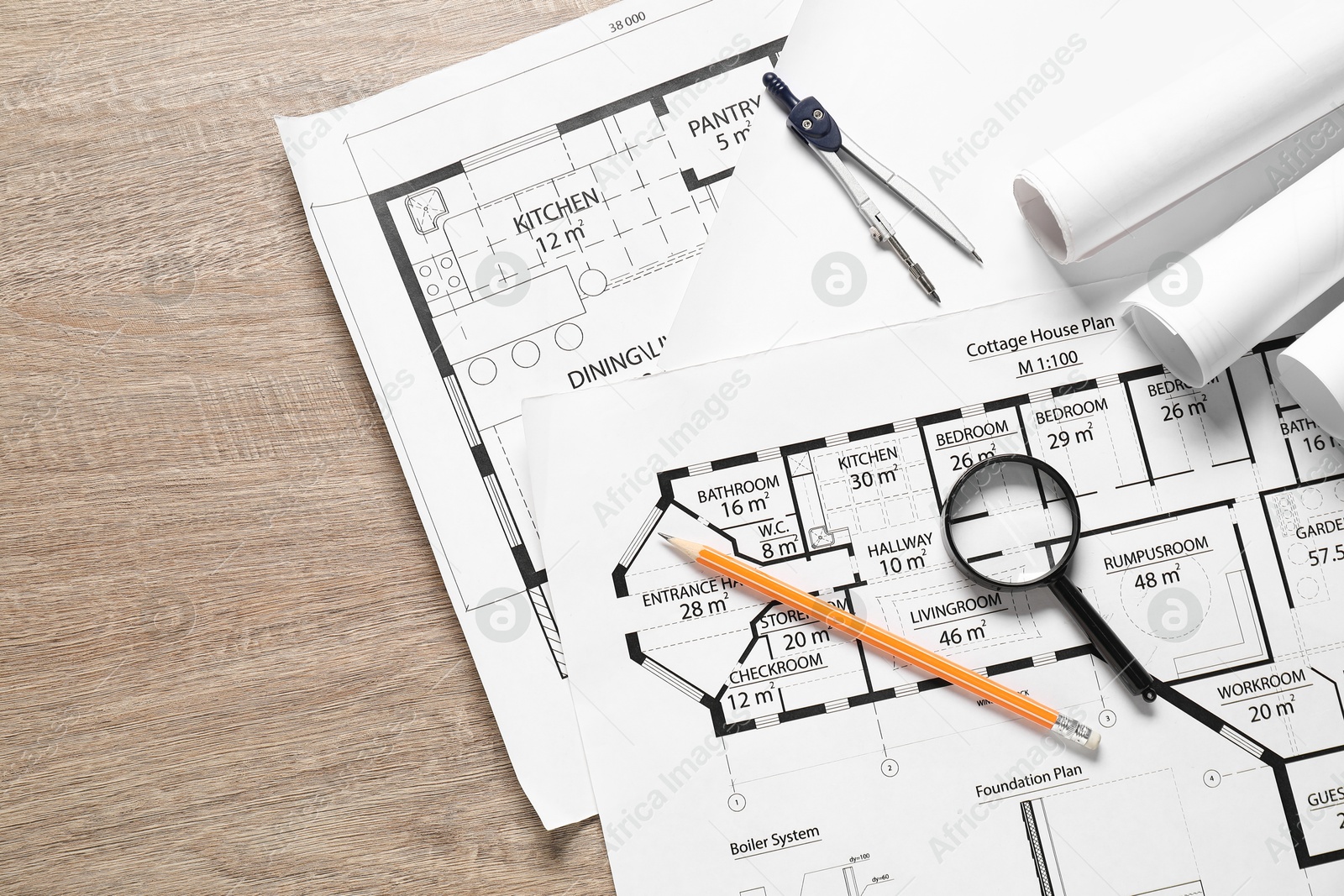 Photo of Different engineering drawings, dividers, pencil and magnifying glass on wooden table, top view