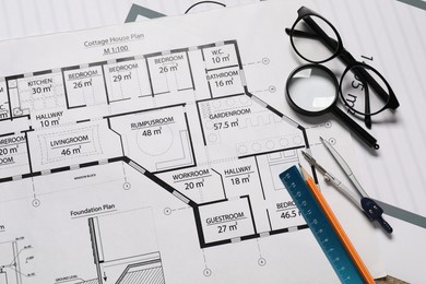 Photo of Pencil, dividers, ruler, glasses and magnifying glass on different engineering drawings, top view