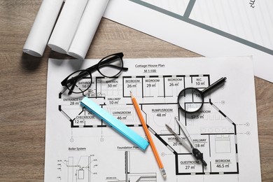 Photo of Different engineering drawings, pencil, dividers, ruler, glasses and magnifying glass on wooden table, flat lay