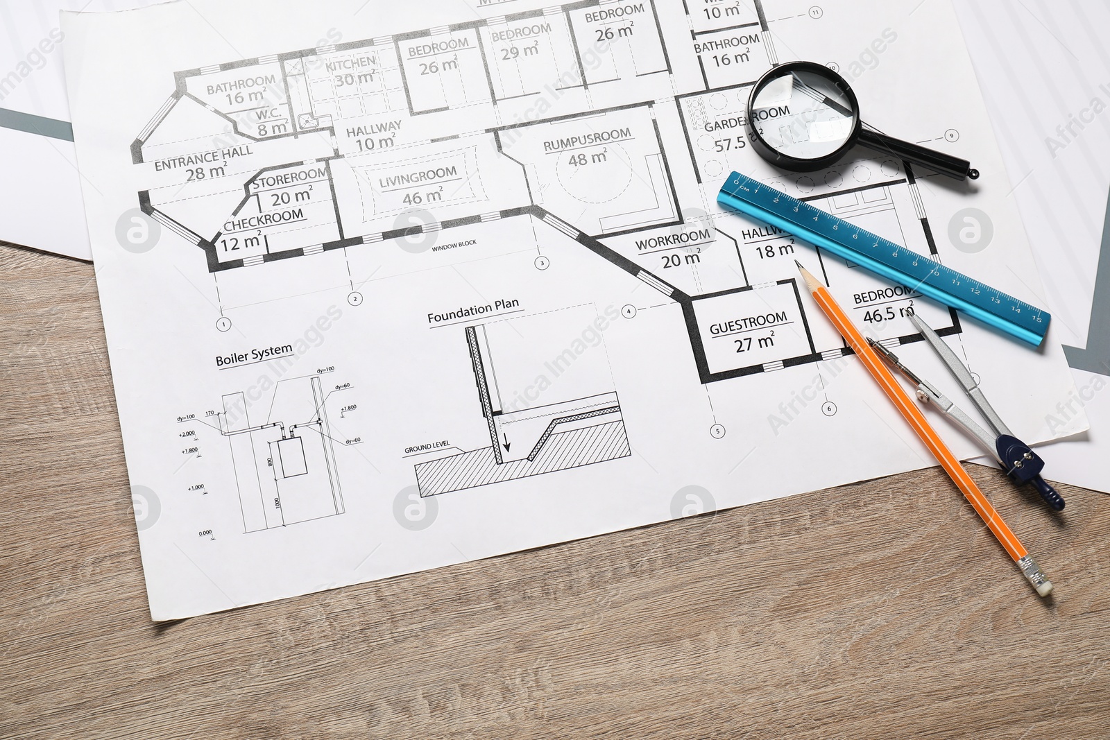 Photo of Different engineering drawings, pencil, dividers, ruler and magnifying glass on wooden table, flat lay