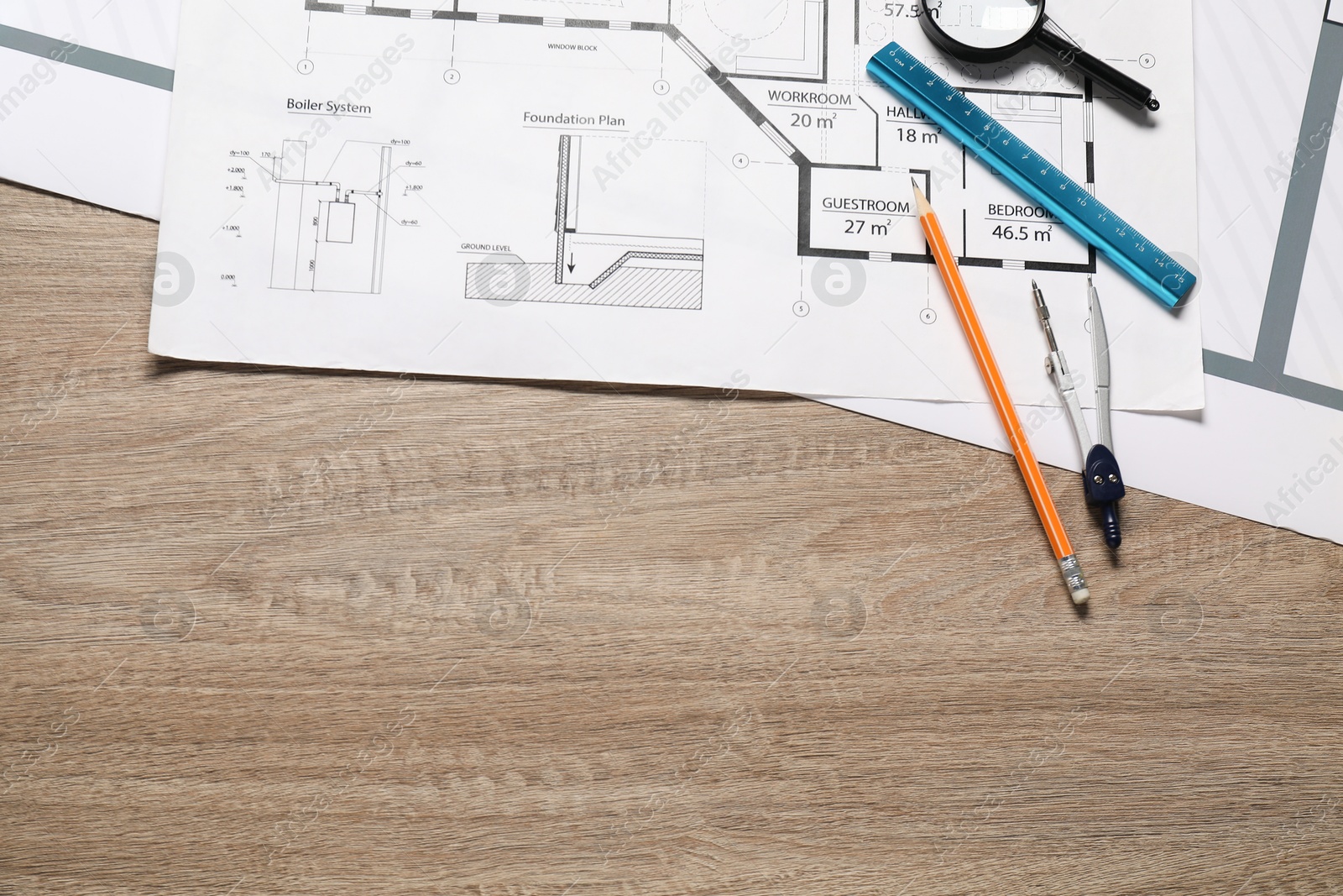 Photo of Different engineering drawings, pencil, dividers, ruler and magnifying glass on wooden table, flat lay