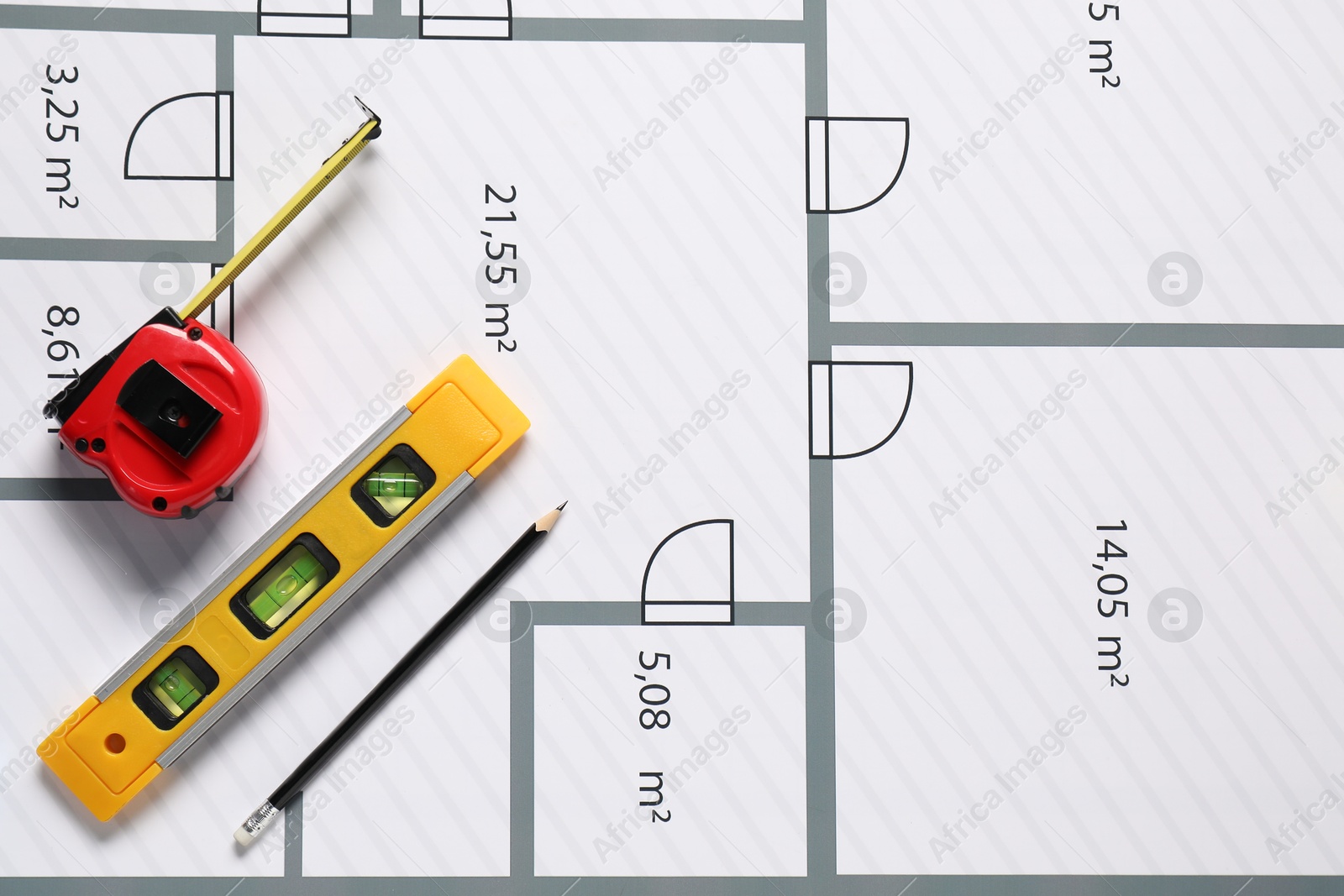 Photo of Pencil, measuring tape and building level on different architectural drawings, top view