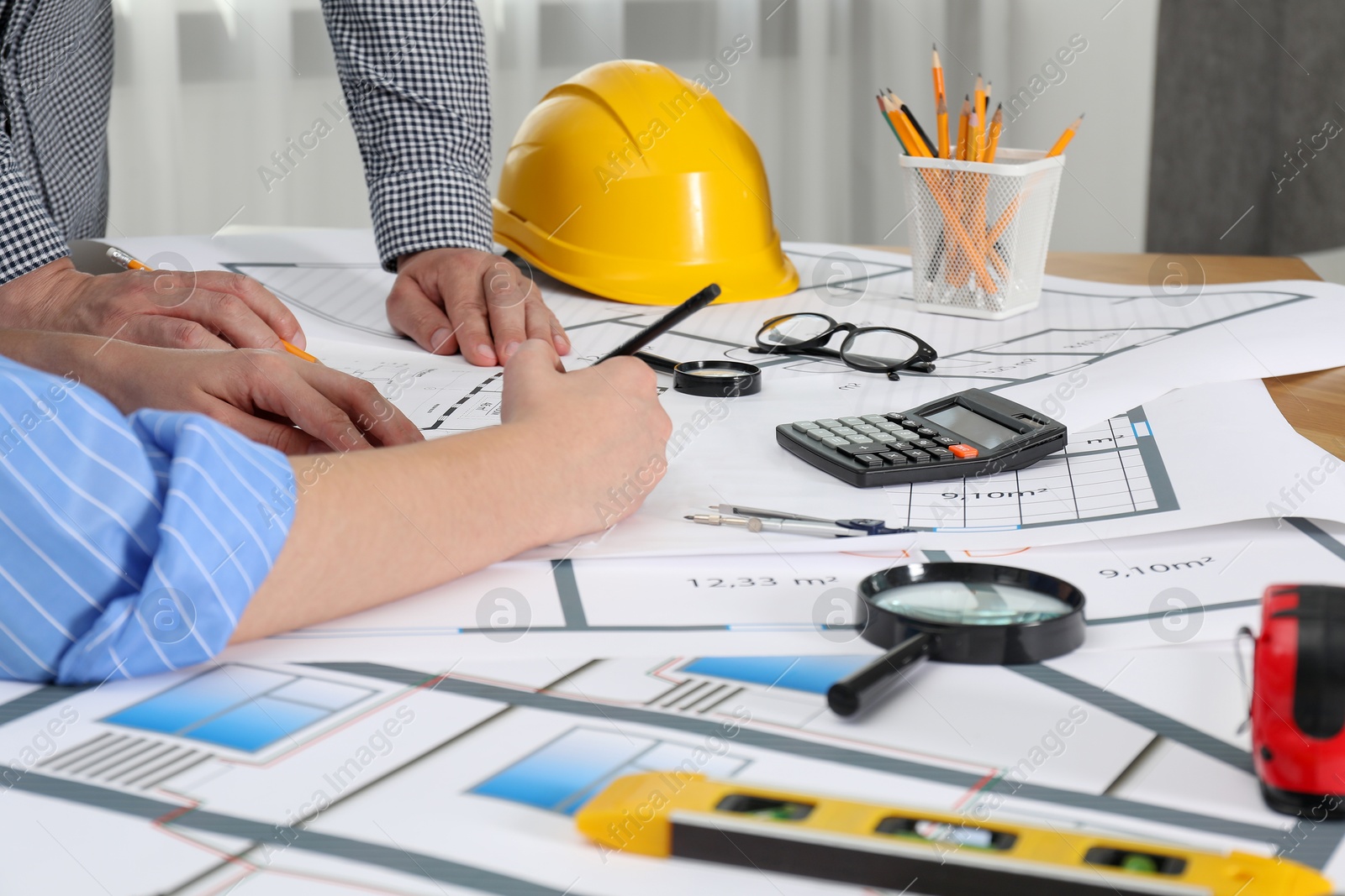 Photo of Architects working with project at table in office, closeup