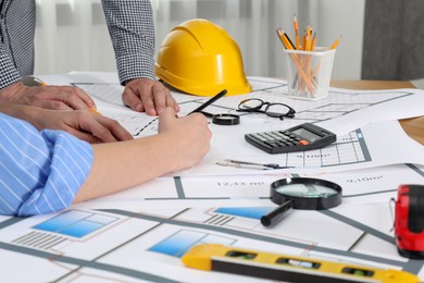 Architects working with project at table in office, closeup