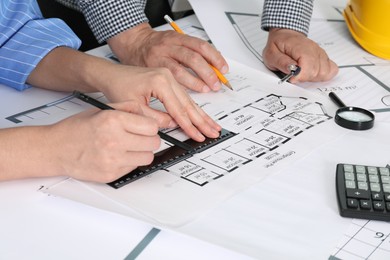 Photo of Architects working with project at table in office, closeup