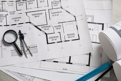 Photo of Different engineering drawings and tools on grey table, flat lay