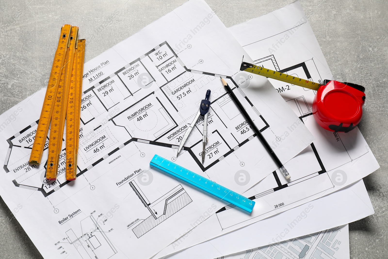 Photo of Different engineering drawings and tools on grey textured table, flat lay