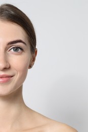 Photo of Beautiful young woman after henna eyebrows dyeing on light background, closeup