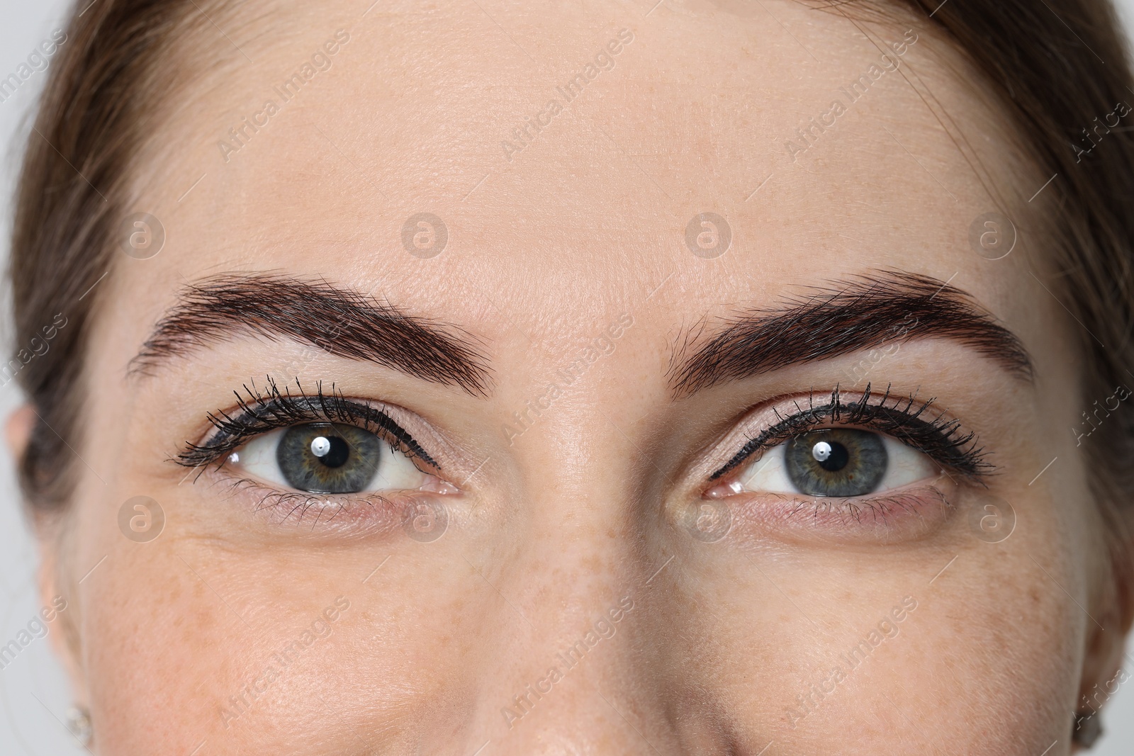 Photo of Beautiful young woman after henna eyebrows dyeing, closeup