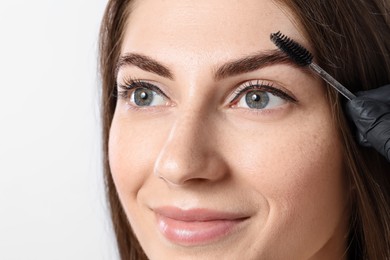 Photo of Beautiful young woman after henna eyebrows dyeing on light background, closeup