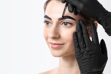 Young woman undergoing henna eyebrows dyeing on white background, closeup. Space for text