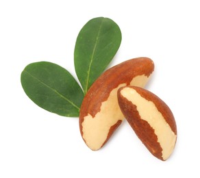 Photo of Tasty Brazil nuts and green leaves isolated on white, top view