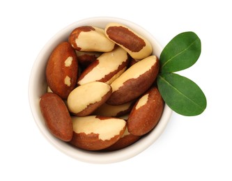 Photo of Tasty Brazil nuts and green leaves in bowl isolated on white